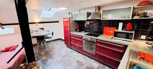 a kitchen with red cabinets and a table in it at Le Chalet des Côtes in Cornimont