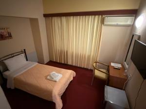 a hotel room with a bed and a television at Cavo D' Oro in Piraeus