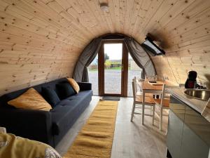 a living room with a blue couch in a house at Black Isle Pods & Chalet in Allangrange Station
