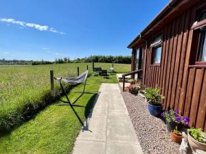 a hammock on a fence next to a house at Black Isle Pods & Chalet in Allangrange Station