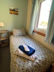 a bedroom with a bed with a hat and a window at Black Isle Pods & Chalet in Allangrange Station