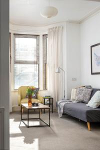 a living room with a couch and a table at NEW Spacious and Bright House-Parking-By FabAccommodation in Bristol +11 photos