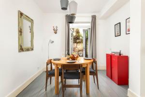 a dining room with a wooden table and a red cabinet at NEW Spacious and Bright House-Parking-By FabAccommodation in Bristol