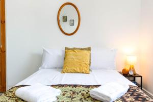 a bedroom with a bed with a mirror on the wall at NEW Spacious and Bright House-Parking-By FabAccommodation in Bristol