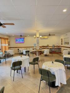 a dining room with tables and chairs and a tv at Hotel Sans Souci in Belén de Escobar +17 photos