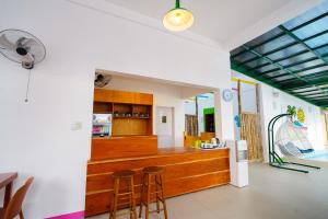 a kitchen with wooden counter and stools in a room at SunDay Hostel in Siquijor