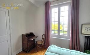 a living room with a chair and a window at Belle de Normandie- Villa Balnéaire d'Exception - Plage au bout de la rue in Ouistreham