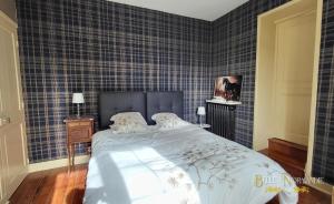 a bedroom with a large bed with blue tiled walls at Belle de Normandie- Villa Balnéaire d'Exception - Plage au bout de la rue in Ouistreham