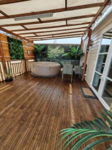 a large deck with a hot tub on a house at Le Havre de la jungle in Montereau
