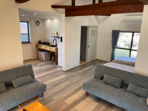 a living room with a bed and two couches at 細島 Base Clutch in Hyuga