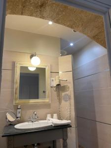 a bathroom with a sink and a mirror at Hôtel l'Amphithéâtre in Nîmes +28 photos