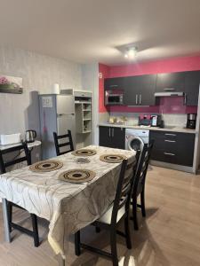 a kitchen with a table and some chairs and a kitchen with at Studio confortable proche thermes in Salins-les-Bains