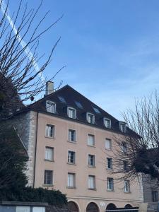 a large pink building with a black roof at Studio confortable proche thermes in Salins-les-Bains