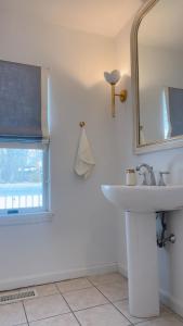 a bathroom with a sink and a mirror and a window at Villa Après Sea in Westport +10 photos