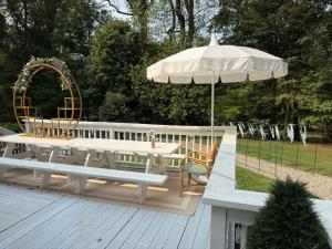 a picnic table and an umbrella on a deck at Villa Après Sea in Westport