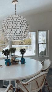 a dining room with a white table and a chandelier at Villa Après Sea in Westport