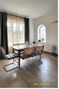 a dining room with a wooden table and chairs at Belle de Normandie- Villa Balnéaire d'Exception - Plage au bout de la rue in Ouistreham