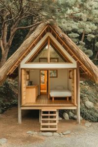 a small house with a thatched roof with a bed at Galoya Cool Cool Hotel in Ampara