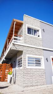 ein weißes Backsteingebäude mit einem Balkon in der Unterkunft Luarca 80 in Santa Clara del Mar