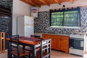 eine Küche mit einem Tisch und einem Kühlschrank in der Unterkunft Luarca 80 in Santa Clara del Mar