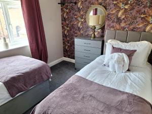 a teddy bear sitting on a bed in a bedroom at Fieldside House Beautiful Sleeps 6 House with Decked Garden in Scarborough
