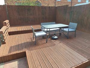 a patio with a table and chairs on a wooden deck at Fieldside House Beautiful Sleeps 6 House with Decked Garden in Scarborough
