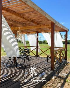 a wooden deck with a table and chairs under a pavilion at Cabaña La Conquista in Goya