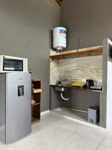 a kitchen with a refrigerator and a microwave at Cabaña La Conquista in Goya