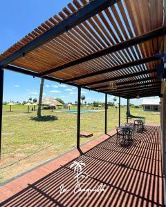 a wooden pergola with tables and chairs on a patio at Cabaña La Conquista in Goya
