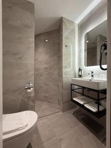 a bathroom with a toilet and a sink and a shower at OZO Hotels Antares Amsterdam Schiphol Airport in Hoofddorp +37 photos