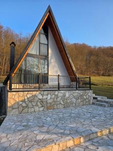 a house with a large window and a stone patio at Kozara Resort in Gornji Podgradci