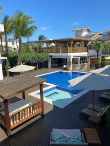 a resort with a swimming pool and a building at Hotel Maui Maresias in Maresias