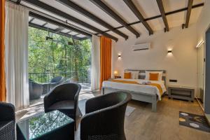a bedroom with a bed and a large window at Leopard Eye Resort in Kitulgala