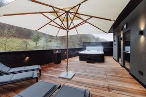 a patio with an umbrella and a bed on a deck at Dillhof Apartments in Eschau