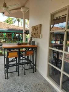 a table and chairs sitting next to a building at Baan Rim Tarn B&B in Takua Pa