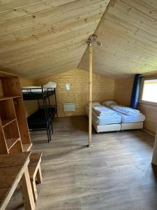 a room with two beds in a wooden cabin at Camping Kautenbach in Kautenbach