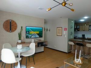 a living room with a table and white chairs at Like a Home - 2Bedrooms - QueenBed - Balcony - Parking - 7Th FLOOR in Quito