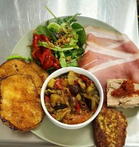 a plate of food with meat and vegetables and a salad at La Cardabelle in Moulinet +1 photo