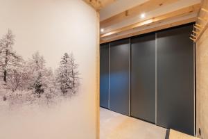 a room with a painting of trees on the wall at Chalet Cocooning avec SPA Les Granges de Thuy in Thônes