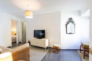a living room with a couch and a tv at Refugio do Outeiro - by Smarthomes in São Martinho do Porto