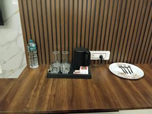 a wooden table with a bottle of water and glasses at Murugammal residency in Tiruppatūr
