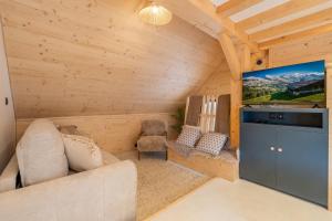 a living room with a couch and a flat screen tv at Chalet Cocooning avec SPA Les Granges de Thuy in Thônes
