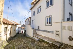 an alley in a town with white buildings at Refugio do Outeiro - by Smarthomes in São Martinho do Porto
