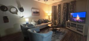 a living room with a couch and a tv at Old Fort Loft King & Queen suites nearest accomodation to Marshals Museum power your EV for free! in Fort Smith
