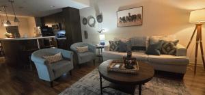 a living room with a couch and two chairs and a table at Old Fort Loft King & Queen suites nearest accomodation to Marshals Museum power your EV for free! in Fort Smith