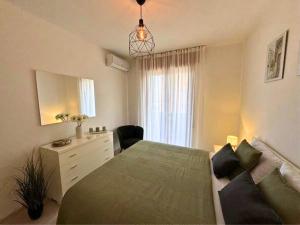 a bedroom with a bed and a dresser and a window at Villa Manuela in Grado