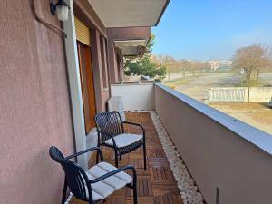 two chairs on a balcony with a view of a street at Villa Manuela in Grado