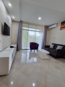 a living room with a couch and a tv at Snow View Residences in Msaranga