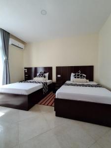 a bedroom with two beds and a window at Snow View Residences in Msaranga +8 photos
