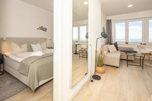 a bedroom and a living room with a bed and a table at Ostsee Suite 4 - Strandperle in Niendorf +13 photos